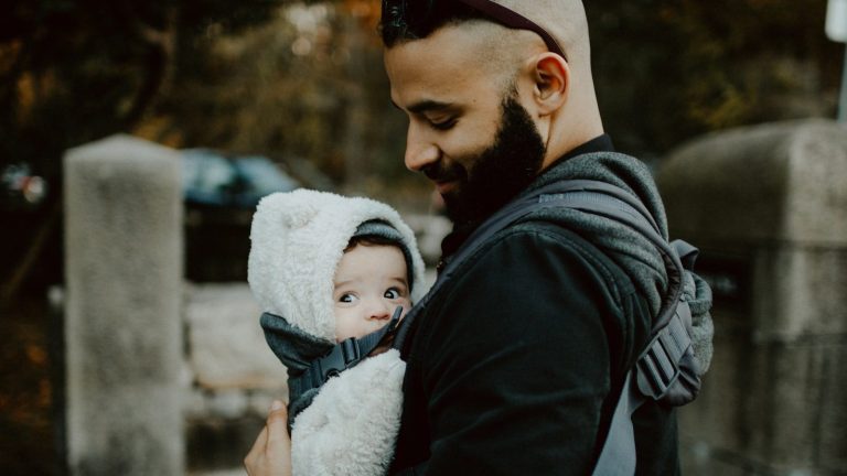 papá porteando a su bebé