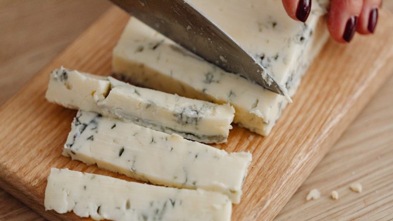 mujer cortando queso gorgonzola
