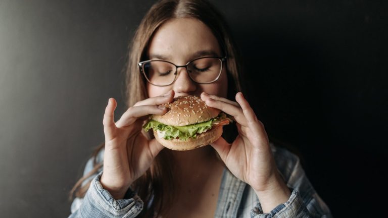 mujer embarazada comiendo hamburguesa